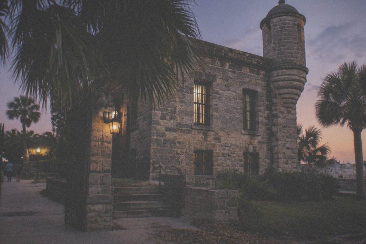 Stone facade of the 1891 Old Jail building in St. Augustine under an evening sky