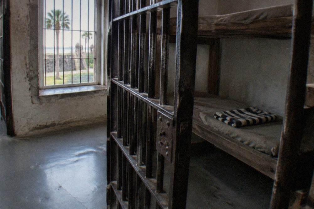 Old jail cells with iron bars and wooden bunks inside the St. Augustine Old Jail museum