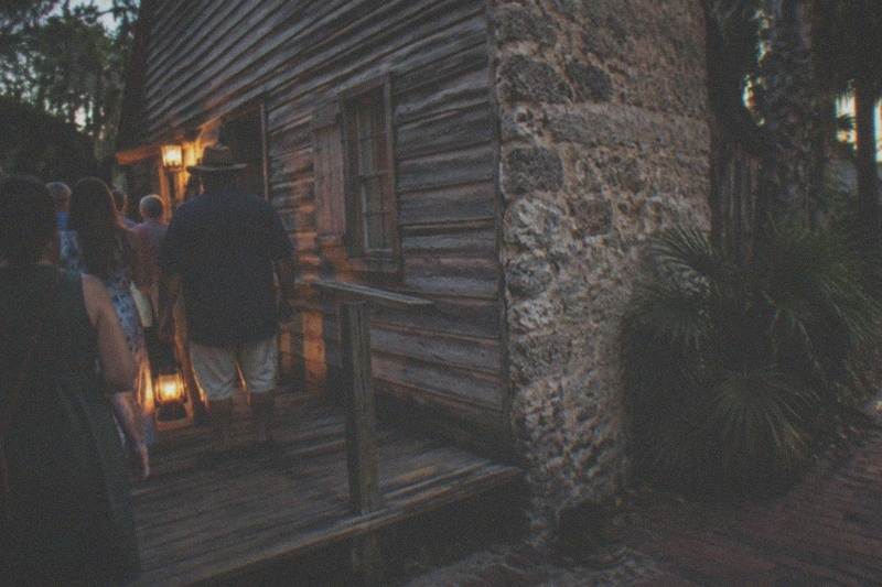 A lantern-lit evening walking ghost tour group in the historic district of St. Augustine, Florida
