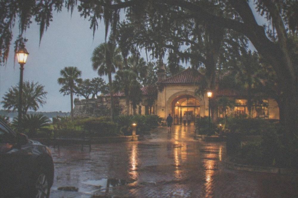 A lit visitor center entrance at dusk with an open plaza in front