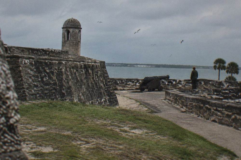 The coquina walls of the Castillo de San Marcos at dusk above the bayfront grass