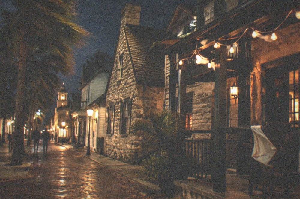 A narrow brick street in the old town lit by string lights at night