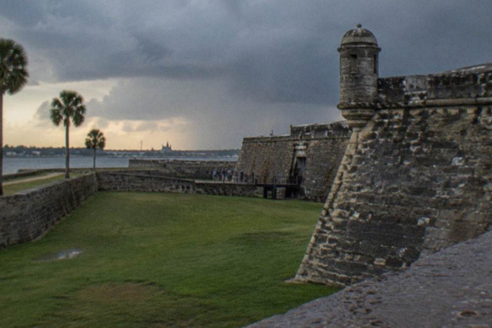 The old stone walls of the Castillo fortress under an evening sky