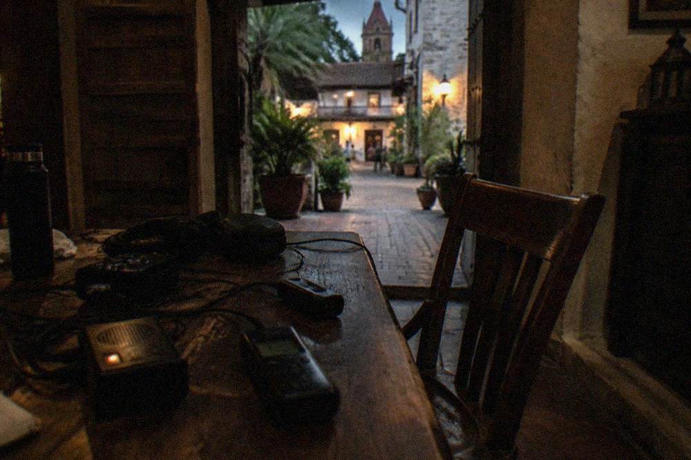 Ghost hunting equipment laid out on a wooden table in a dimly lit room