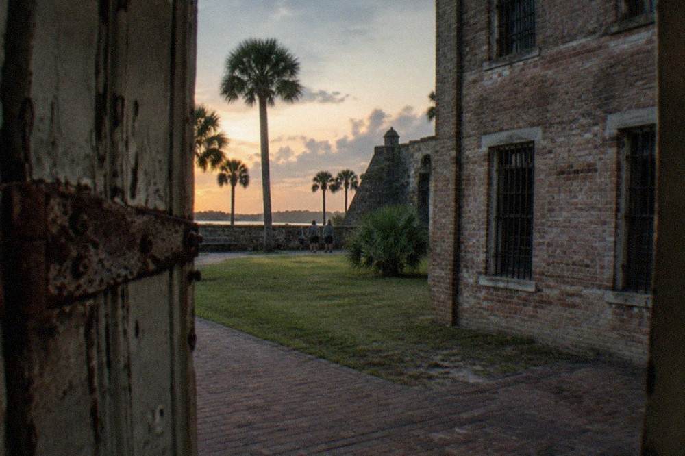 Historic jail building with barred windows and thick masonry walls at dusk